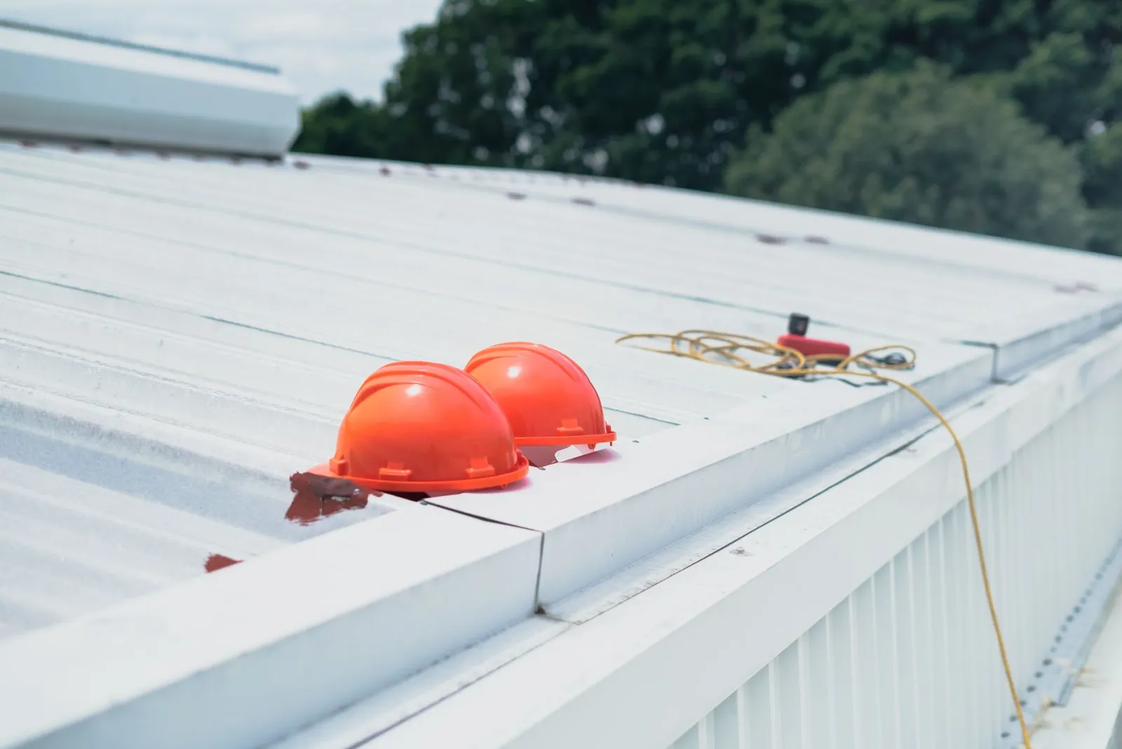 Roof inspector with a clipboard and camera examining shingles and flashing