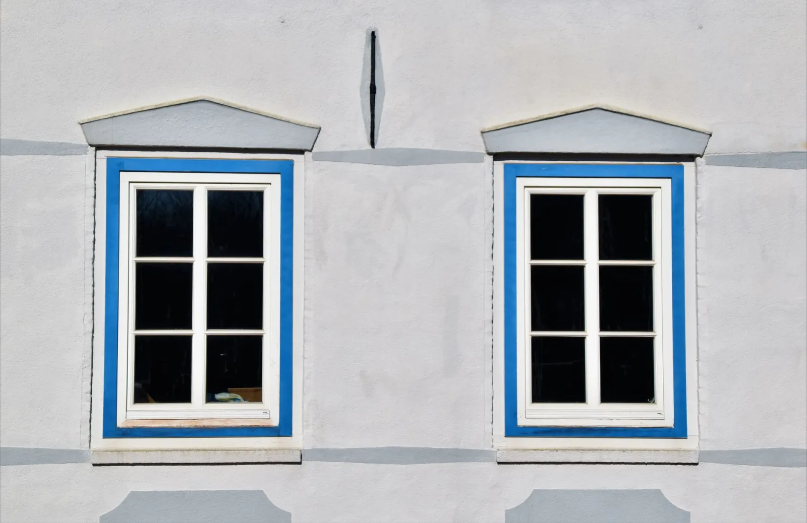 Old single-pane wooden window with frost beside a new double-pane window